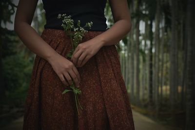 Midsection of woman holding plant