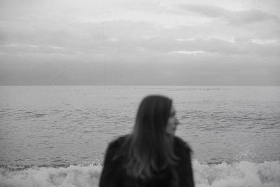 Woman looking at sea against sky