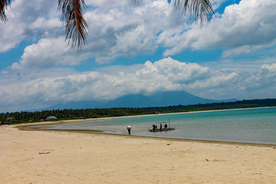 People on beach against sky