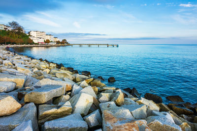 Scenic view of sea against blue sky in city