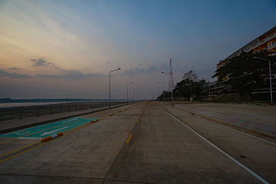 Road by street against sky during sunset