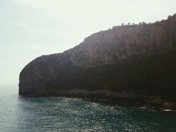 View of calm sea against mountain range
