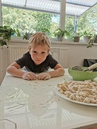 Portrait of cute boy at table at home