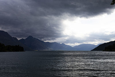 Scenic view of lake by mountains against sky