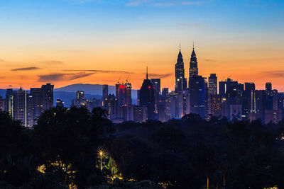 View of illuminated buildings against sky during sunset