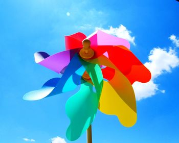 Low angle view of pinwheel against blue sky