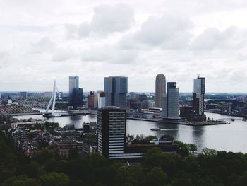 Cityscape by river against sky