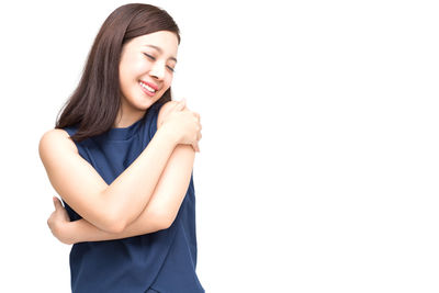 Portrait of a smiling young woman against white background