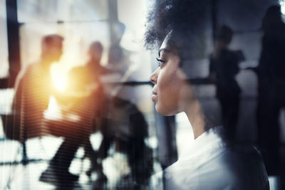 Close-up of woman looking through window