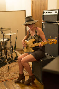 Young female musician playing a bass guitar