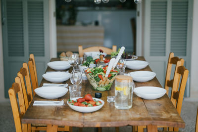 Dining table with chairs and dinner at patio in backyard