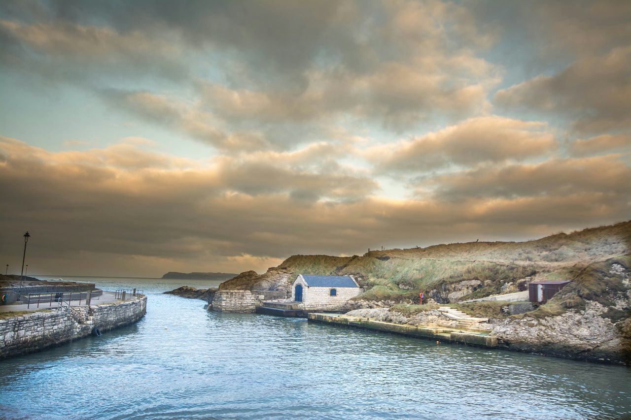 water, sky, waterfront, sunset, cloud - sky, cloudy, sea, architecture, building exterior, built structure, scenics, cloud, tranquil scene, beauty in nature, tranquility, river, rippled, nature, overcast, weather