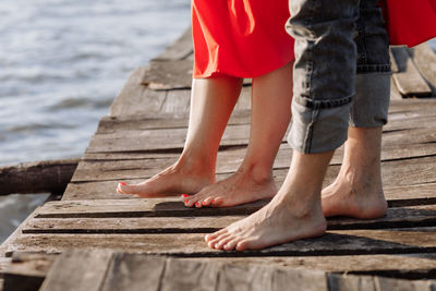 Low section of man standing on boardwalk