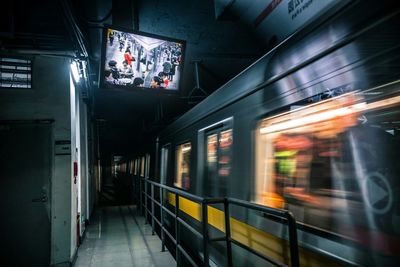 Train at illuminated railroad station at night