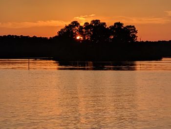 Scenic view of lake against orange sky