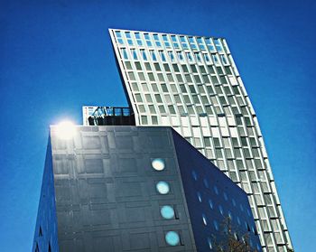 Low angle view of modern building against blue sky