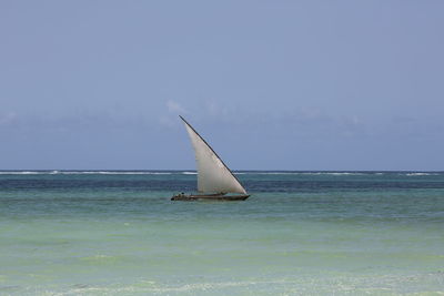 Sailboat in sea against sky