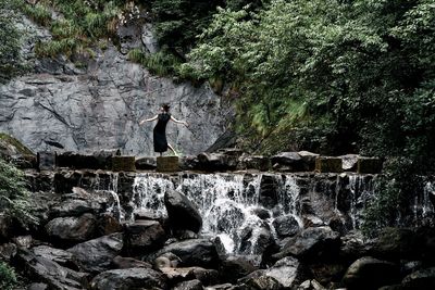 Rear view of man standing on rock