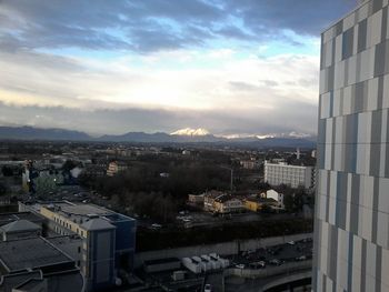 Buildings in town against cloudy sky