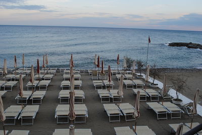 Chairs on beach against sky