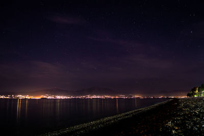 Illuminated city against sky at night