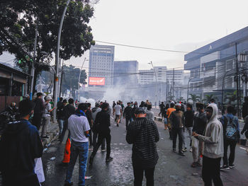 People walking on street in city against sky