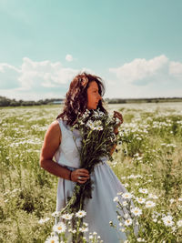 Woman standing on field against sky