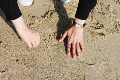 High angle view of hands on sand