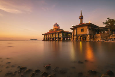 View of building at waterfront during sunset