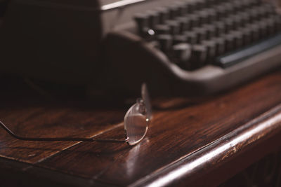 Close-up of eyeglasses by typewriter on table