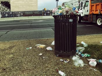 Garbage bin on sidewalk in city