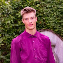 Portrait of young man standing against purple outdoors