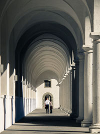 Rear view of man walking in corridor of building