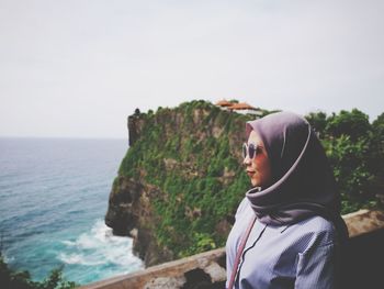 Woman looking at sea against clear sky