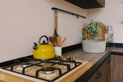 Yellow kettle on a gas stove in the wooden kitchen of a country house 