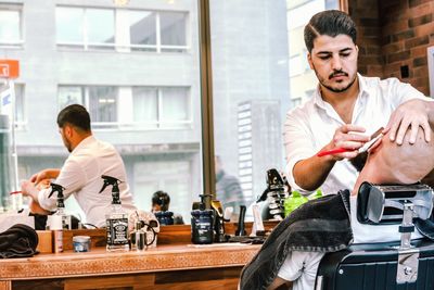 Young man holding food while standing on table