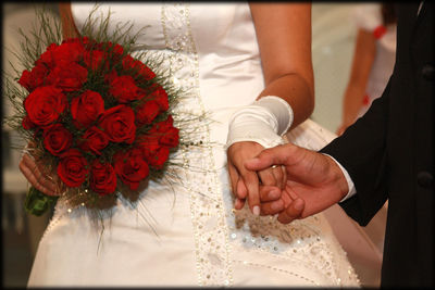 Midsection of couple holding hands