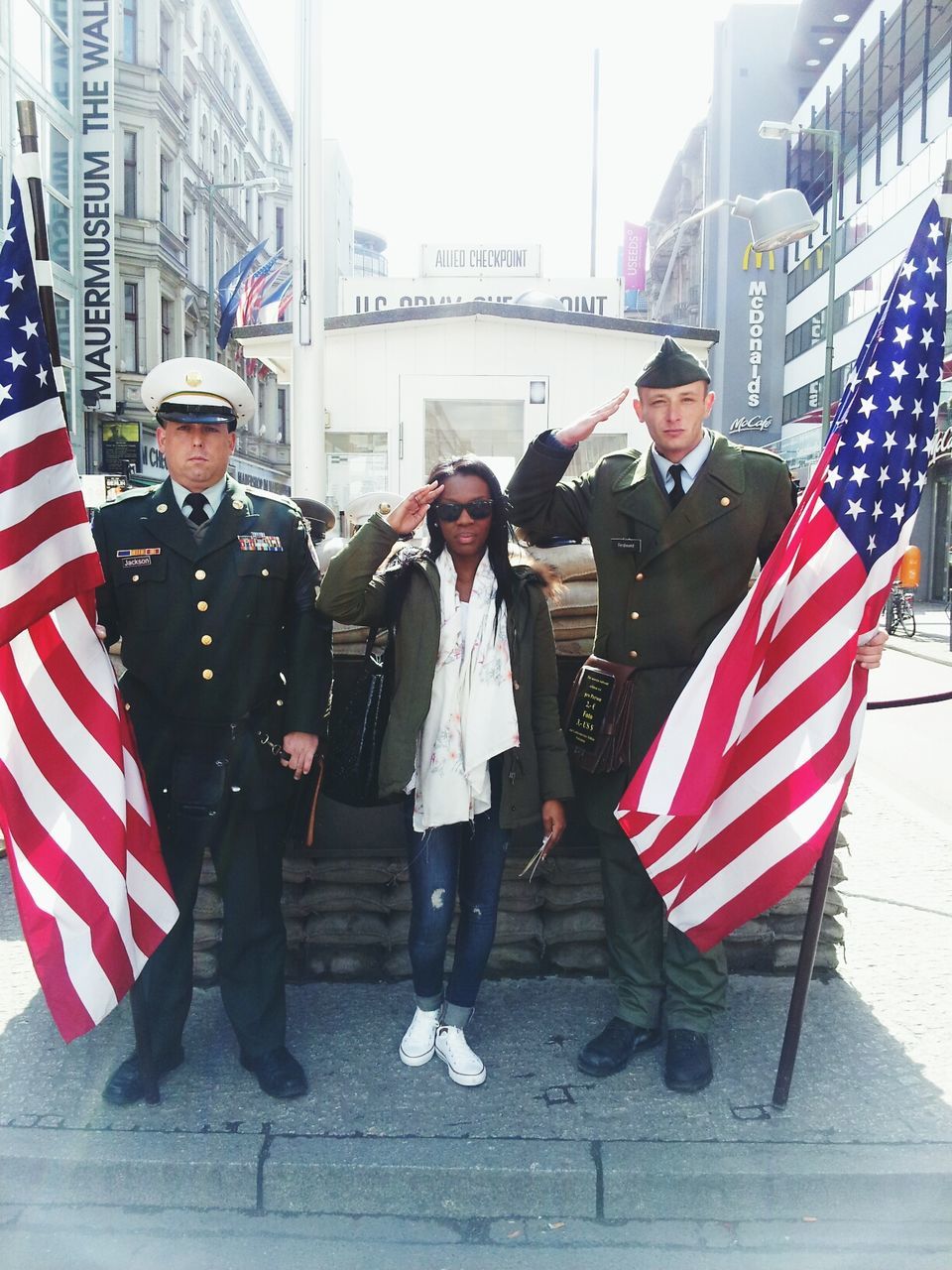 lifestyles, building exterior, architecture, built structure, city, leisure activity, casual clothing, full length, young adult, patriotism, city life, standing, men, young women, communication, street, american flag, person