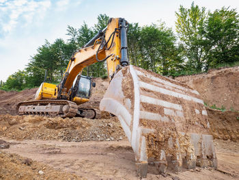 Heavy excavator works on earthmoving at open granite mine. crawler machine excavating in  quarry