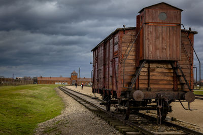 Train on railroad tracks by building against sky