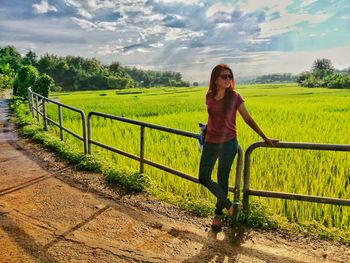 Full length portrait of young woman standing in farm