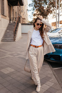 Young woman in white pantsuit and white t-shirt in city location