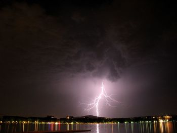 Lightning over sea against sky at night