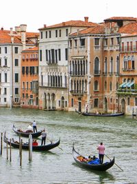 Boats in canal along buildings