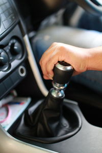 Midsection of man holding gear while driving car