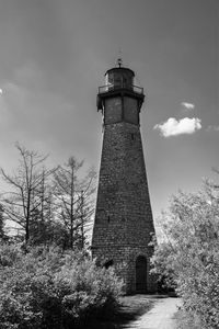 Low angle view of lighthouse amidst buildings against sky