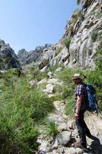 Side view of young man hiking on .mountain in forest