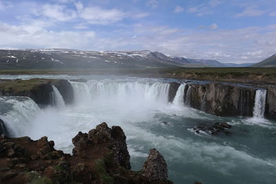 Scenic view of waterfall against sky