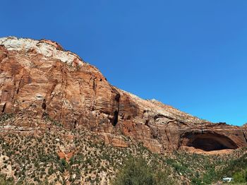 Low angle view of rock formation against clear blue sky