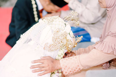 Midsection of bride holding wedding dress